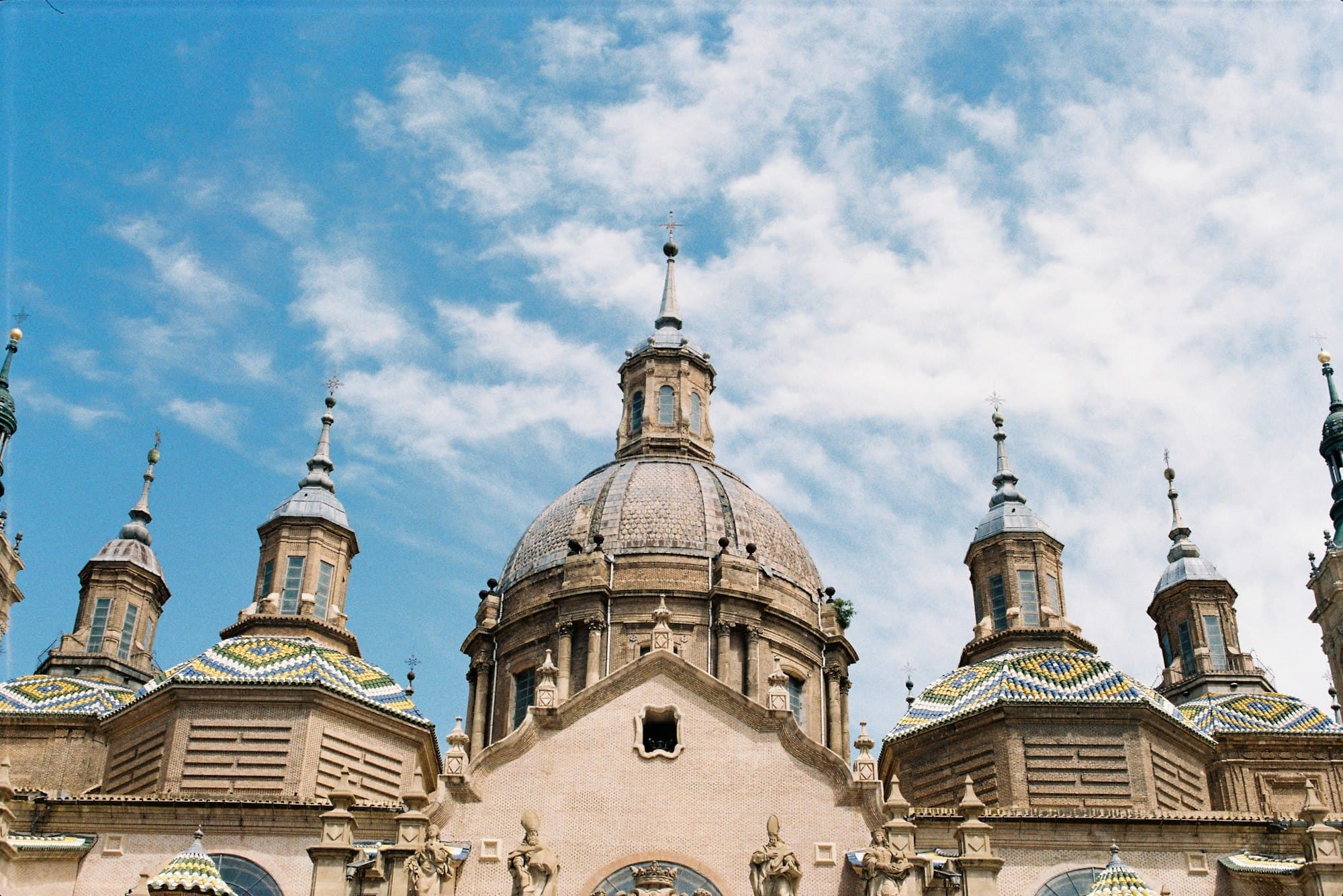 Ornate cathedral domes with colorful tiled roofs against a blue sky