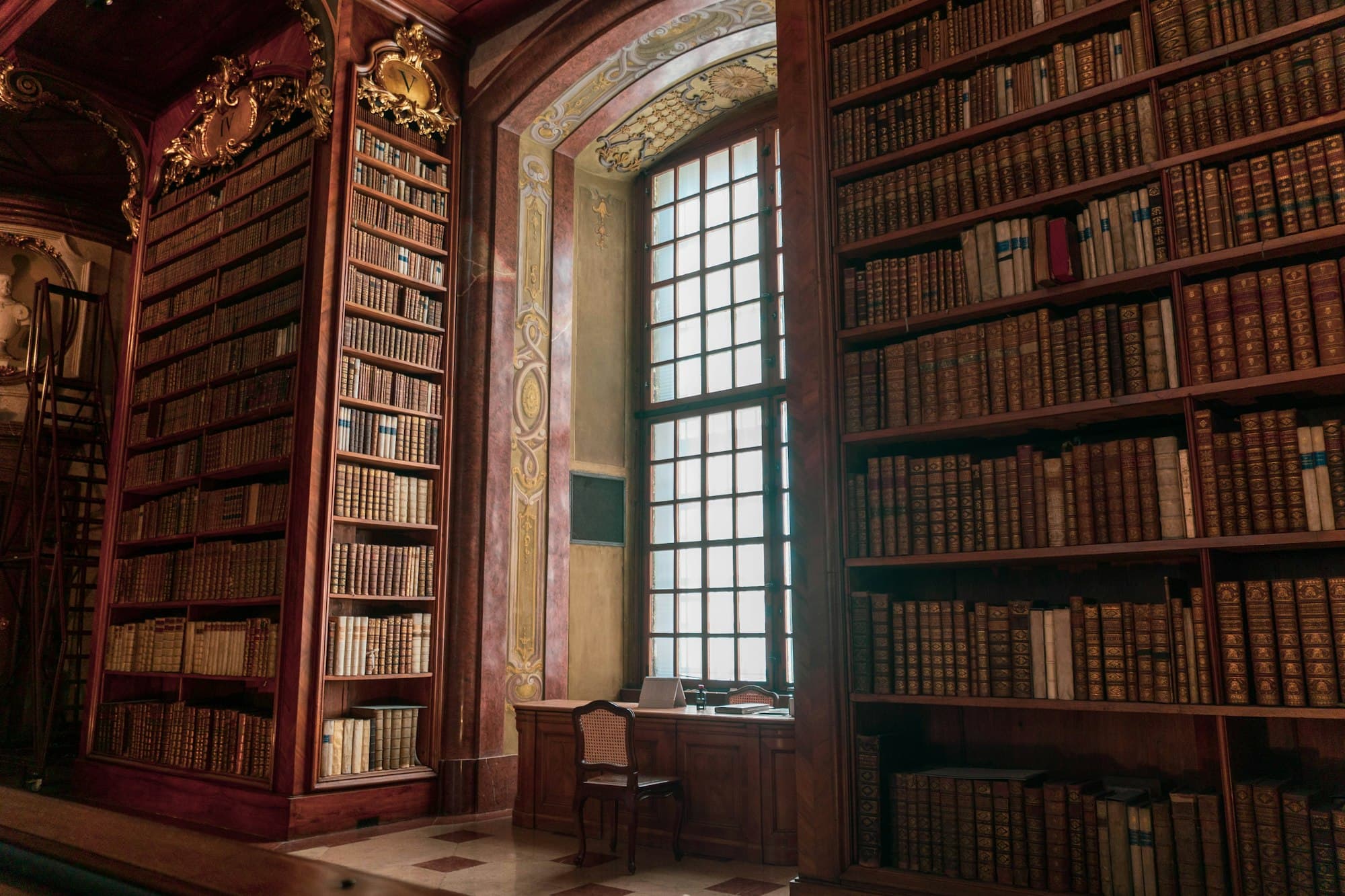 A historic library with tall wooden shelves of antique books beside a tall window