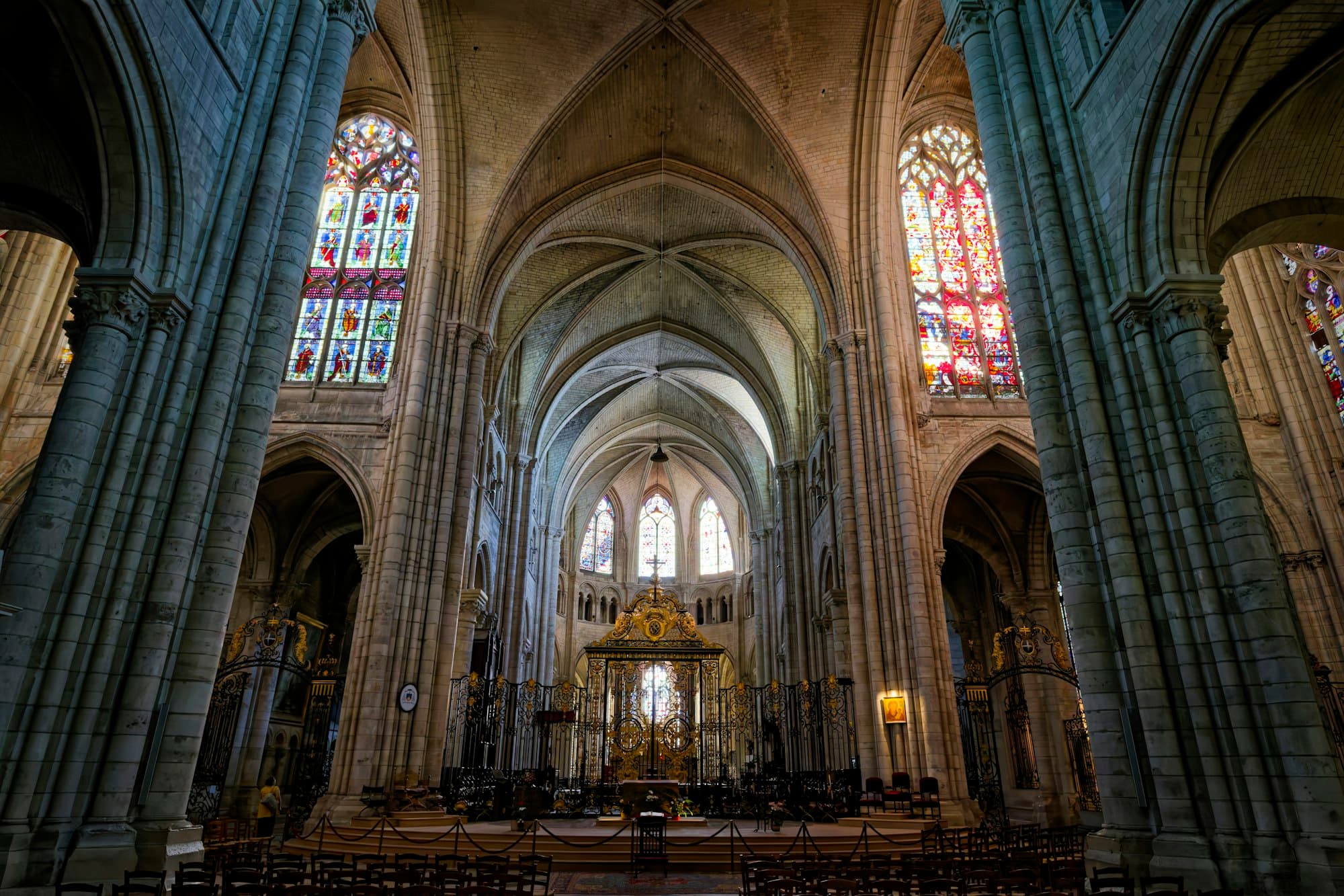 The interior of a Gothic cathedral with stone columns and stained glass windows