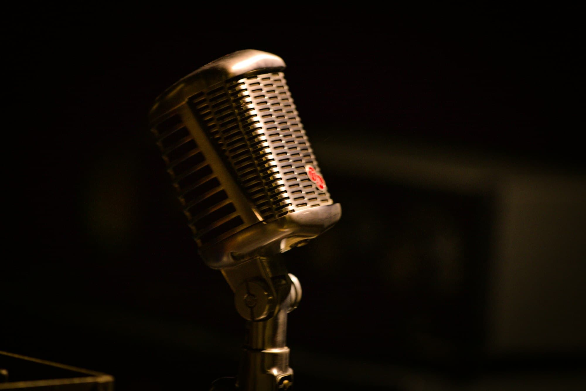 A vintage chrome microphone against a dark background
