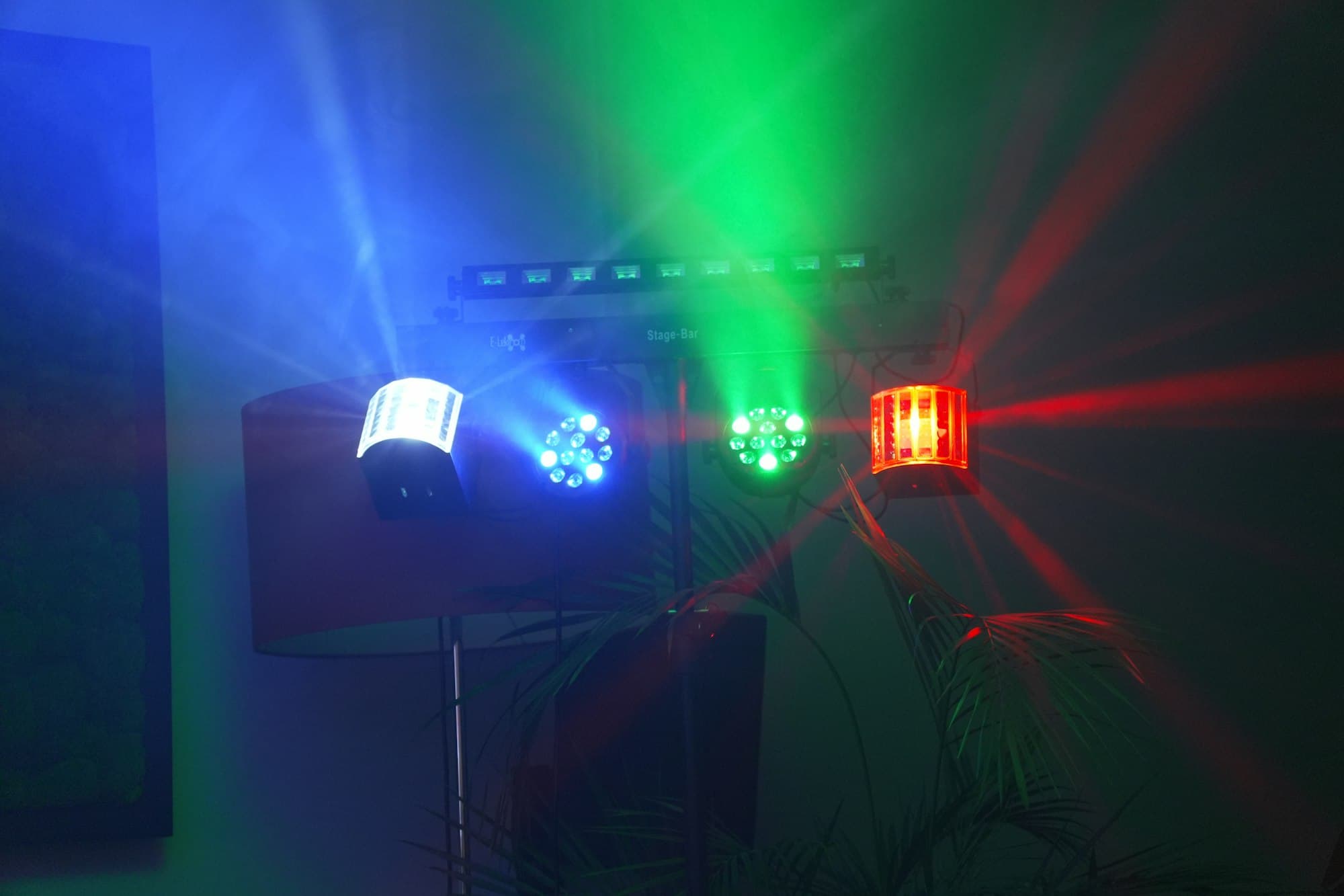 Stage lights casting blue, green and red beams in a dark room