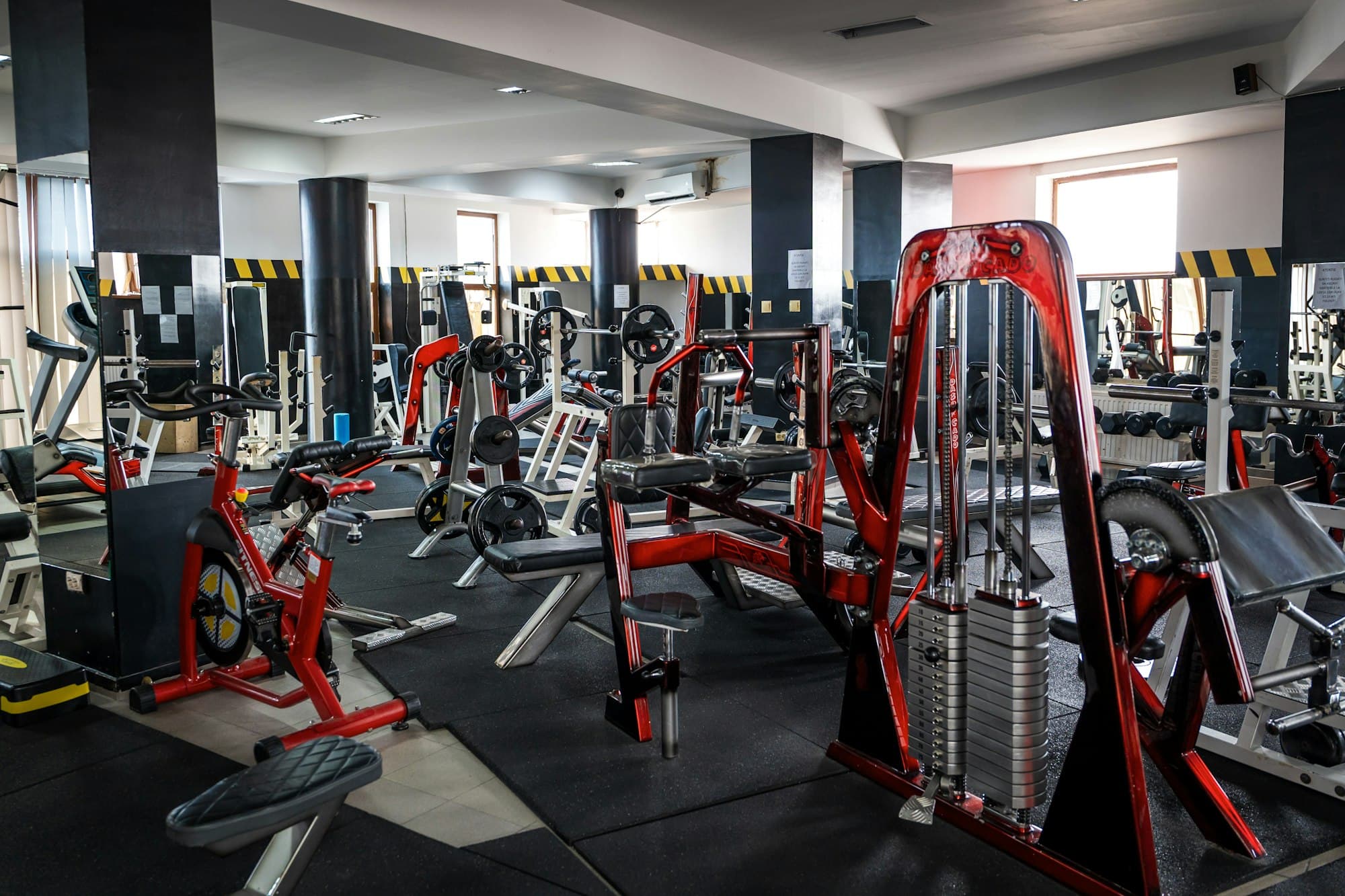 A spacious gym with weight machines, benches and exercise bikes