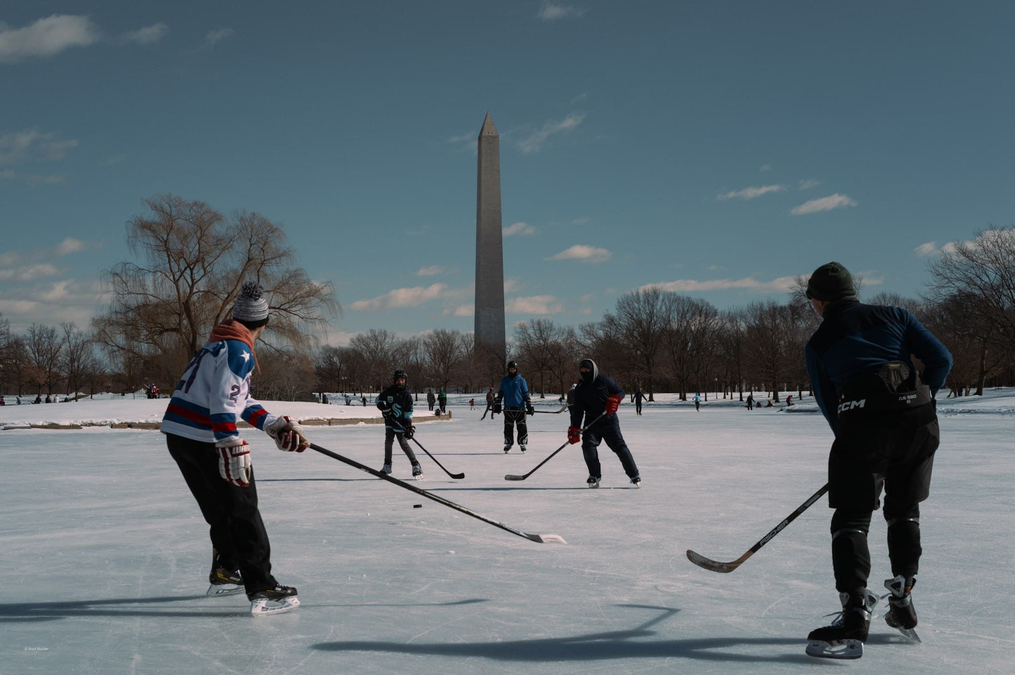 Pond hockey on the frozen Constitution Gardens pond in Washington, DC, with the Washington Monument behind