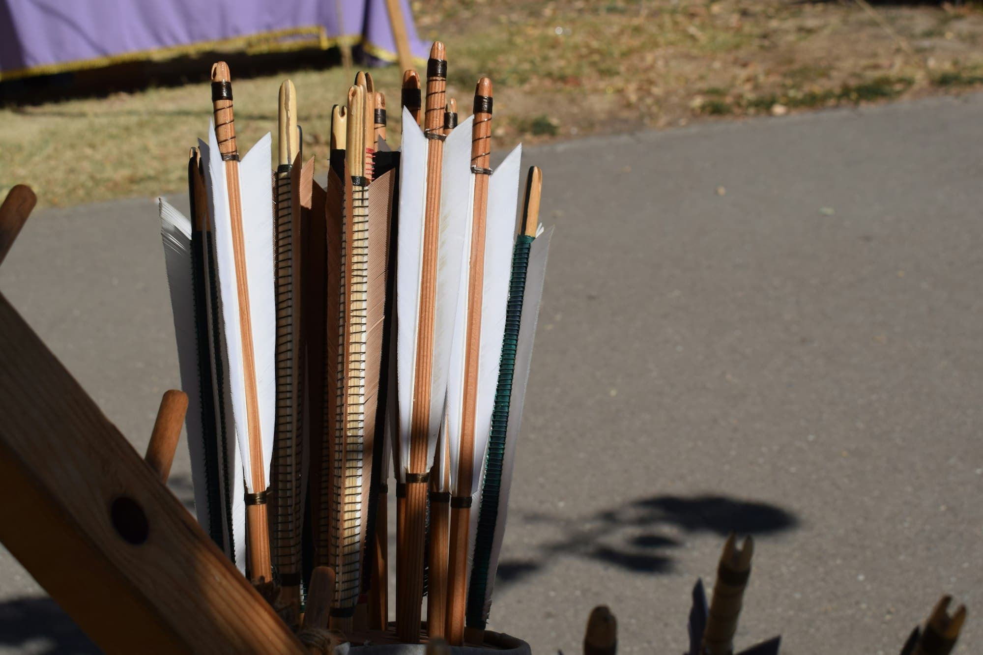 Wooden arrows with white fletching in a quiver outdoors