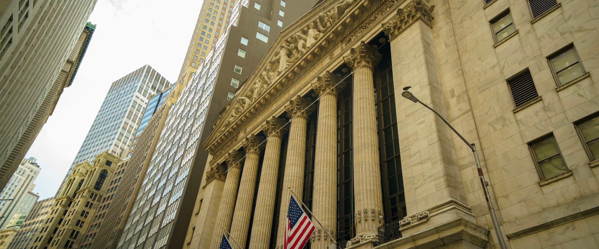 The columned New York Stock Exchange building among skyscrapers in the financial district