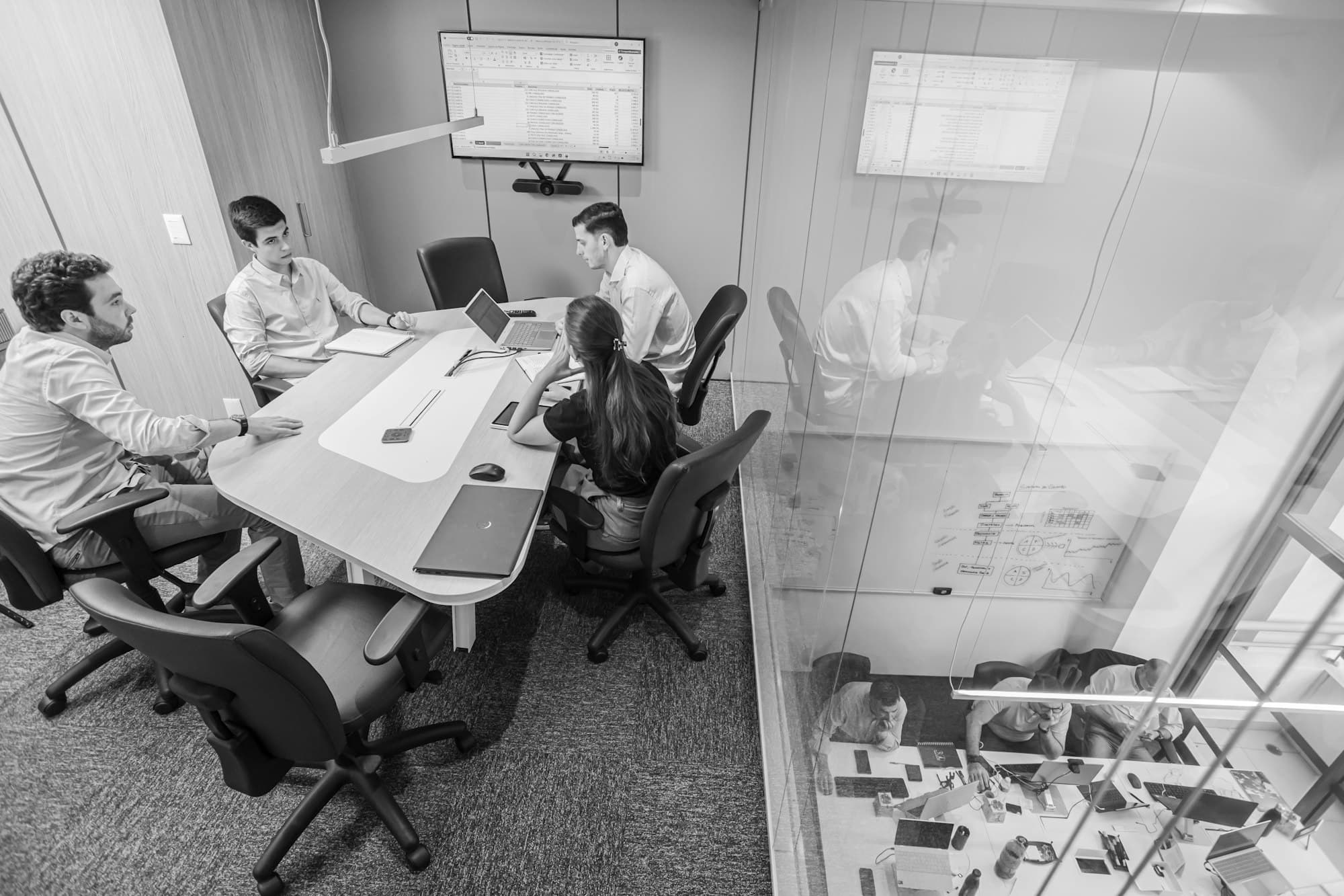 Colleagues in a team meeting around a table in a modern conference room