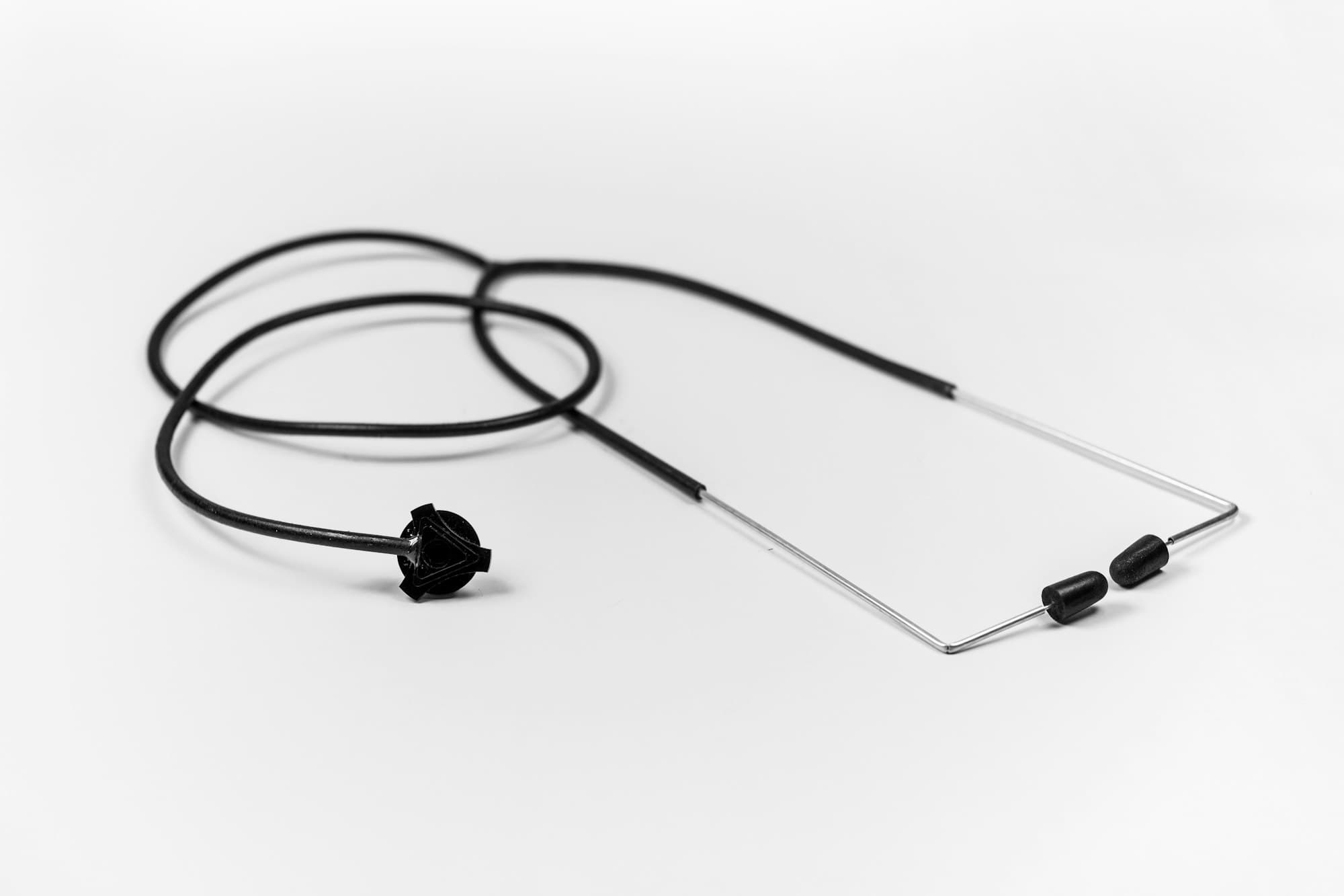 A black stethoscope on a white surface