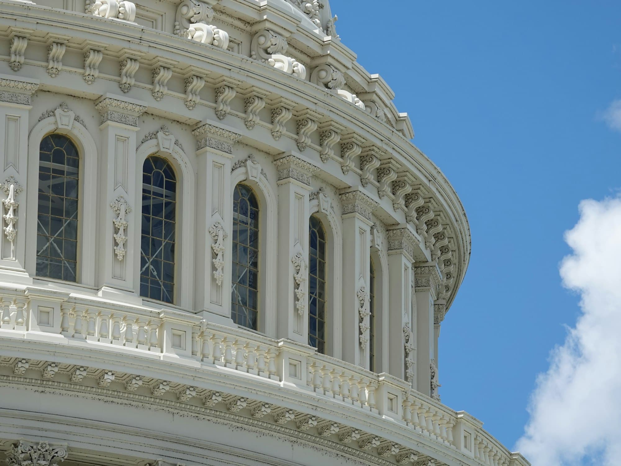 The white neoclassical dome of the United States Capitol under a blue sky