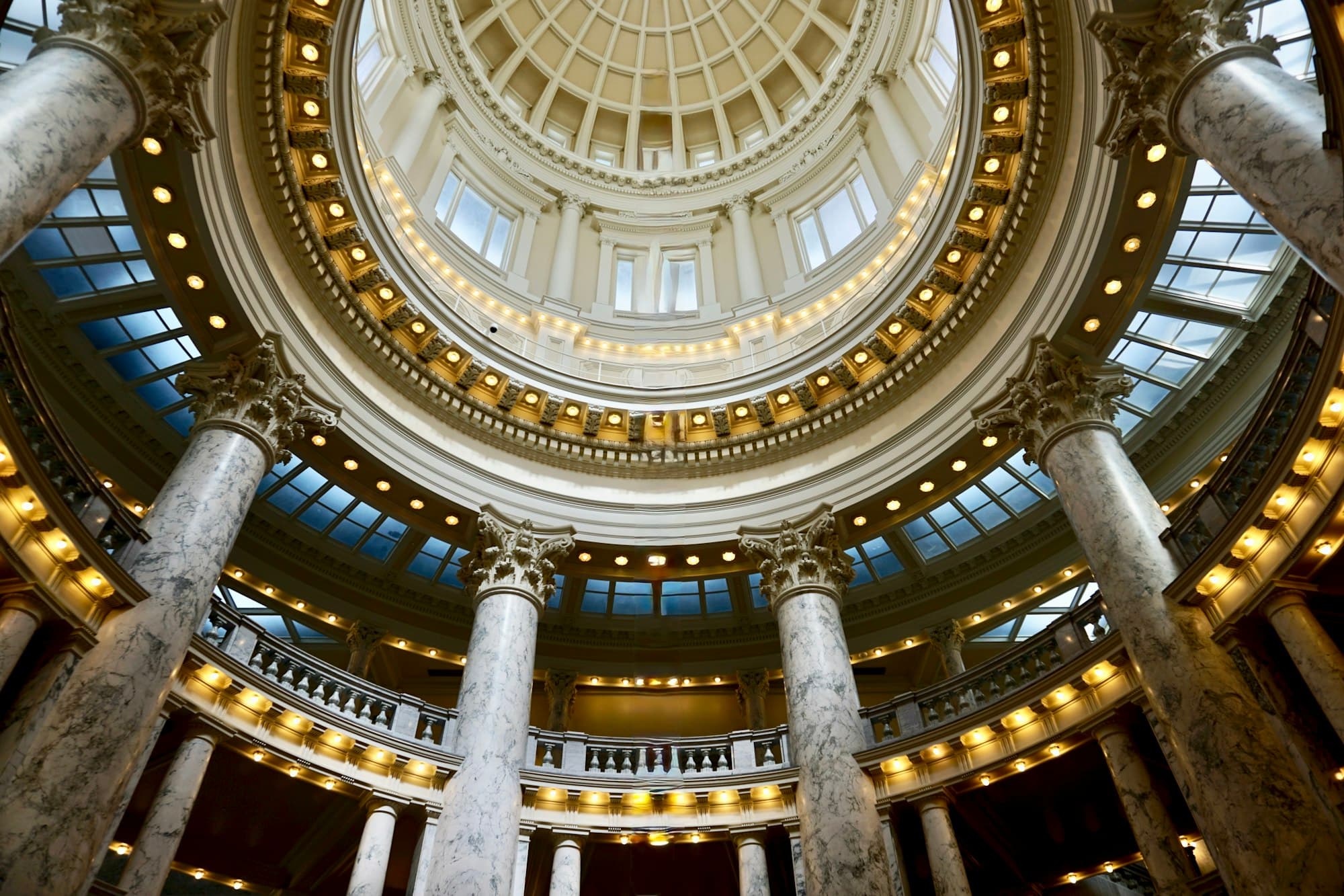 The domed rotunda of a state capitol building with marble columns