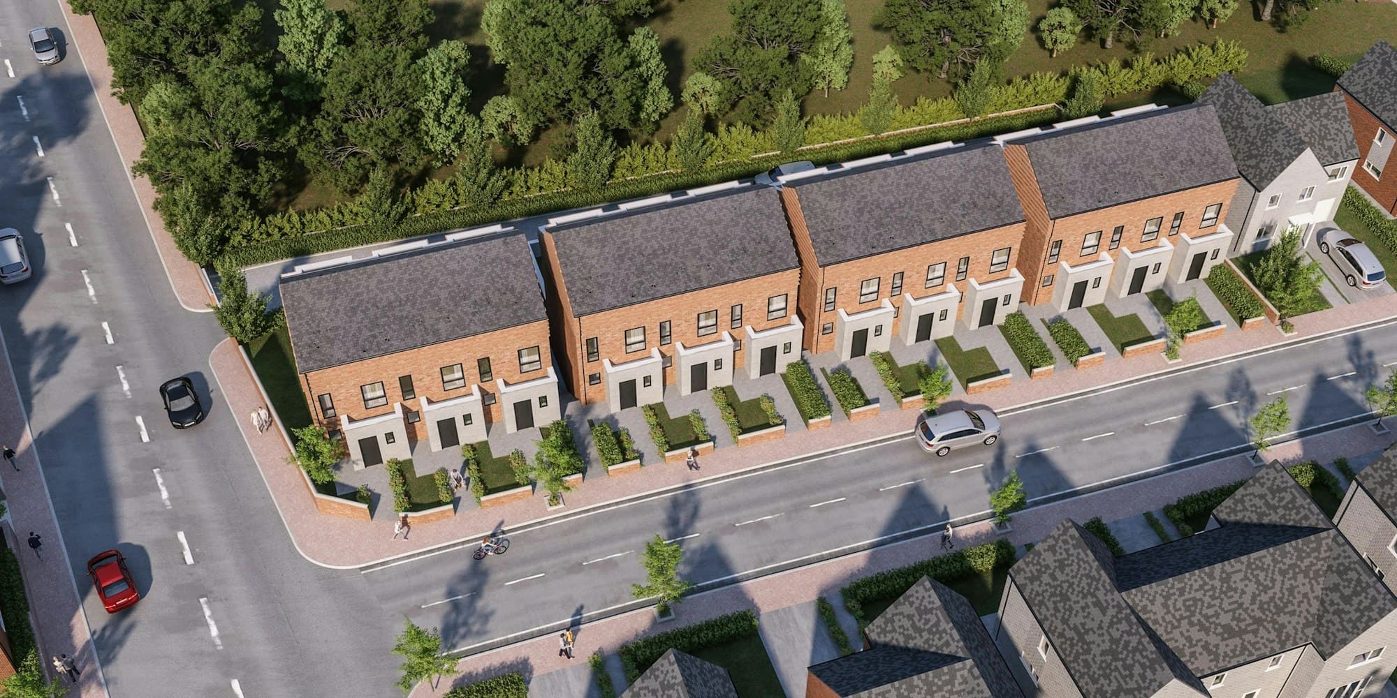 An aerial view of a row of brick townhouses with small front gardens