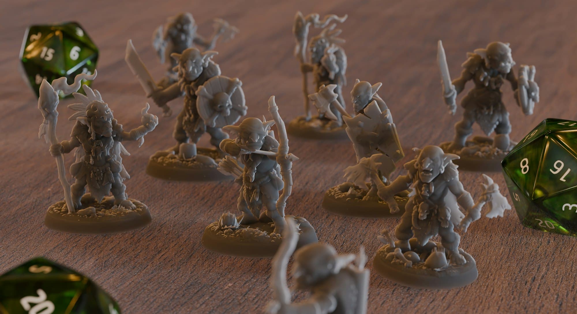 Grey goblin miniatures with weapons and shields on a wooden table beside green twenty-sided dice