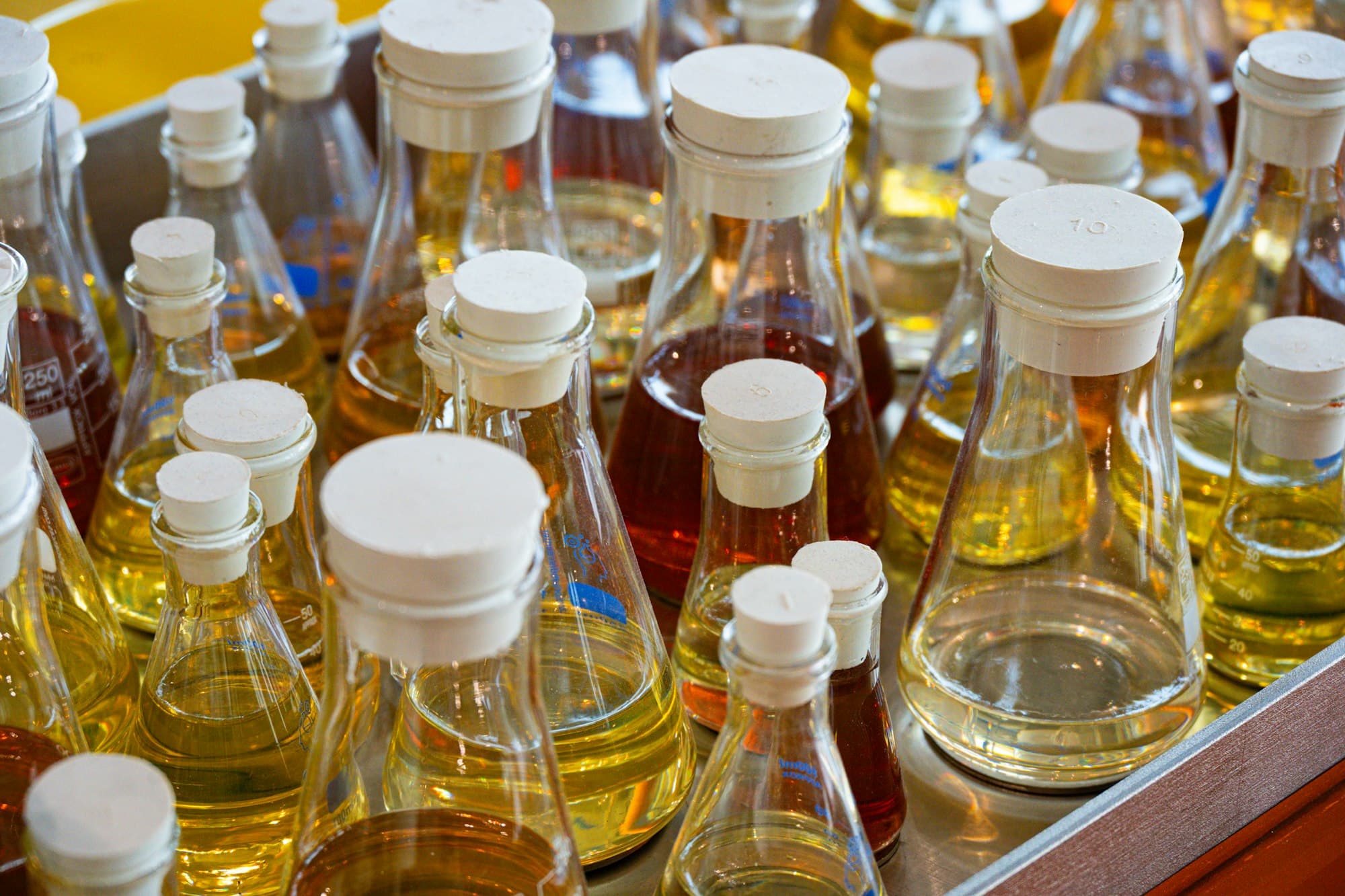 Many stoppered glass flasks filled with colourful liquids