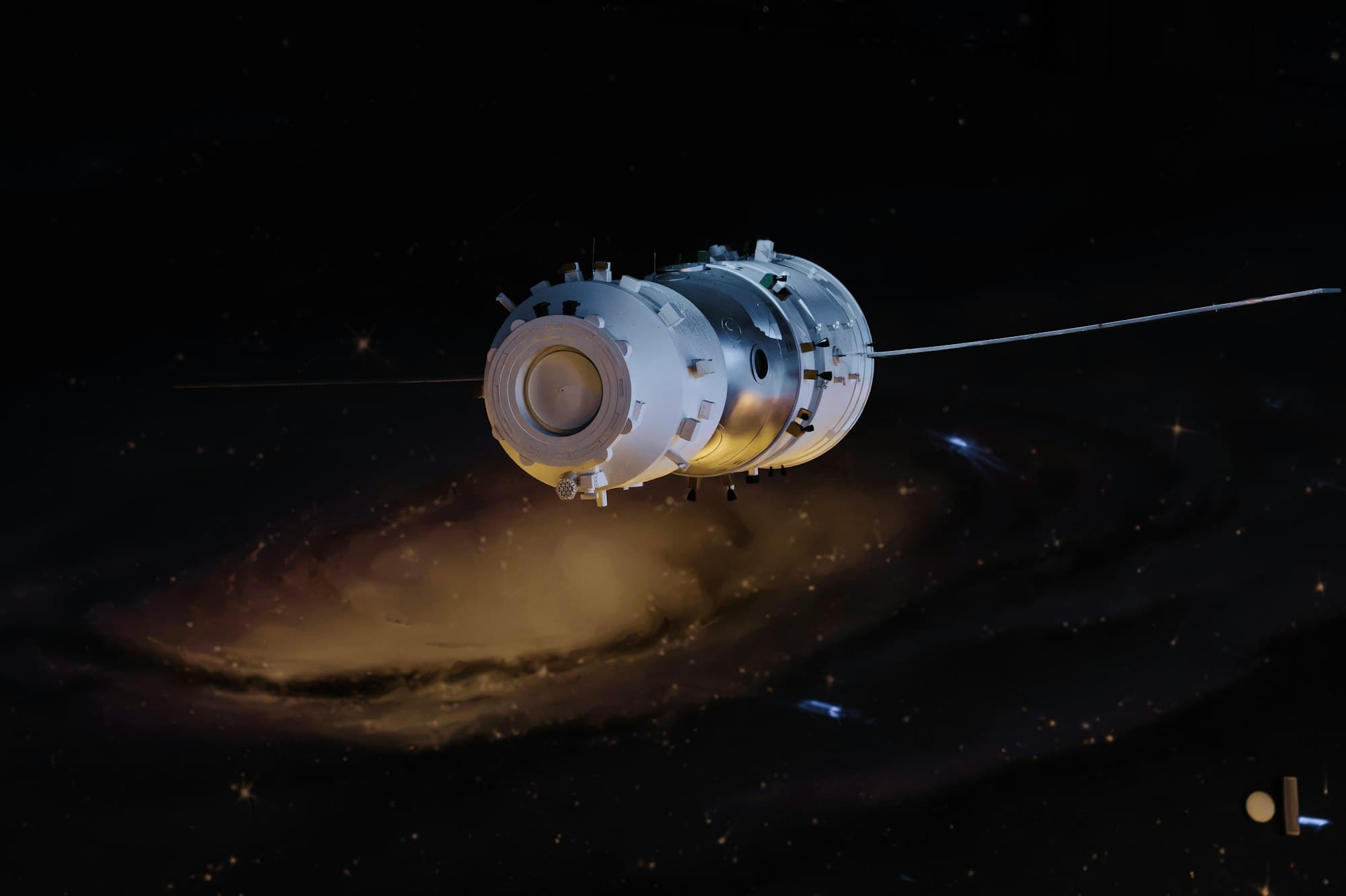A white spacecraft floats in deep space above a spiral galaxy