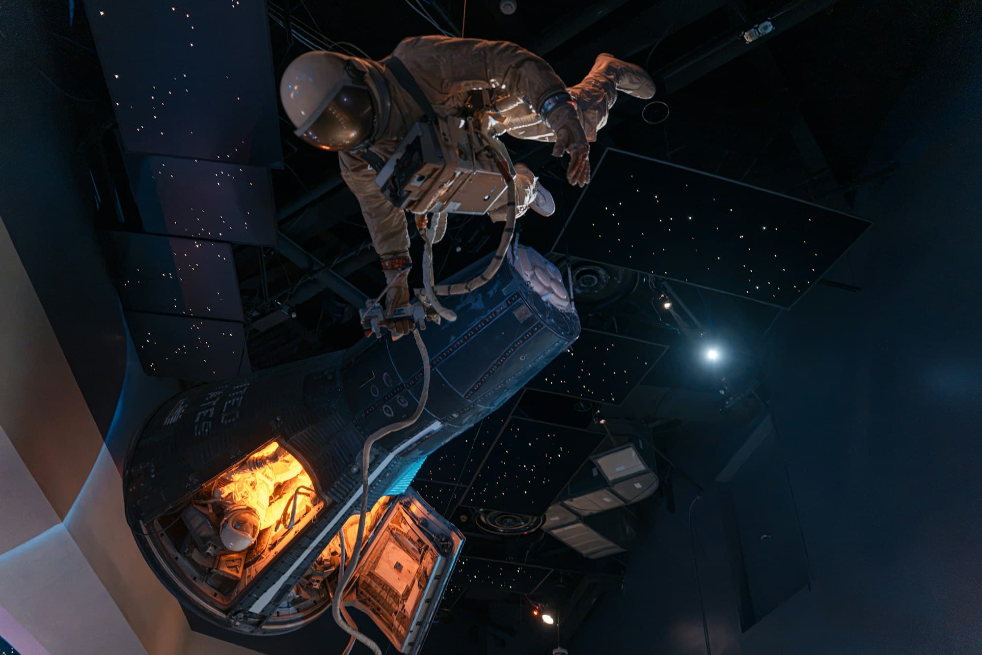 An astronaut in a spacesuit floating beside a space capsule against a starry backdrop