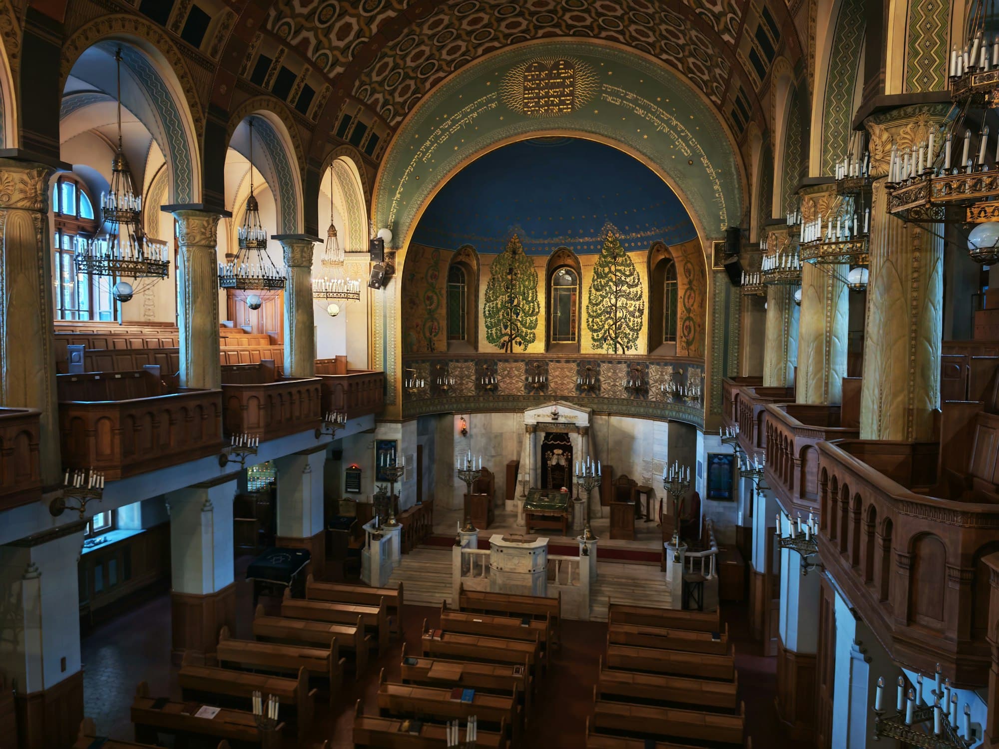 Ornate interior of a historic synagogue with wooden benches and balconies